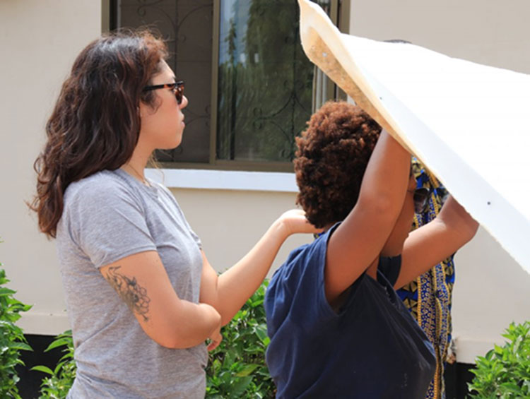 Artists Sungi and Lauren fix the canvas of their artwork.