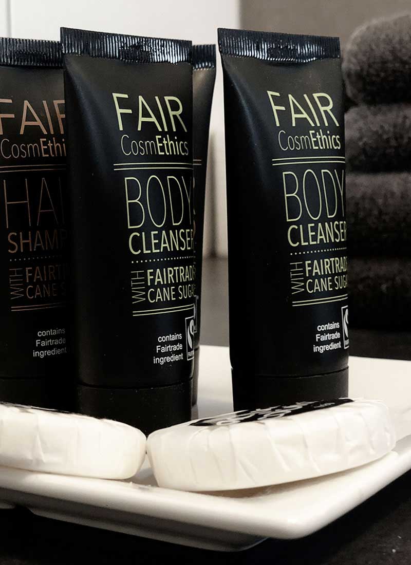 Tubes of Fair CosmETHICS body cleansers and bar soaps on a white dish.