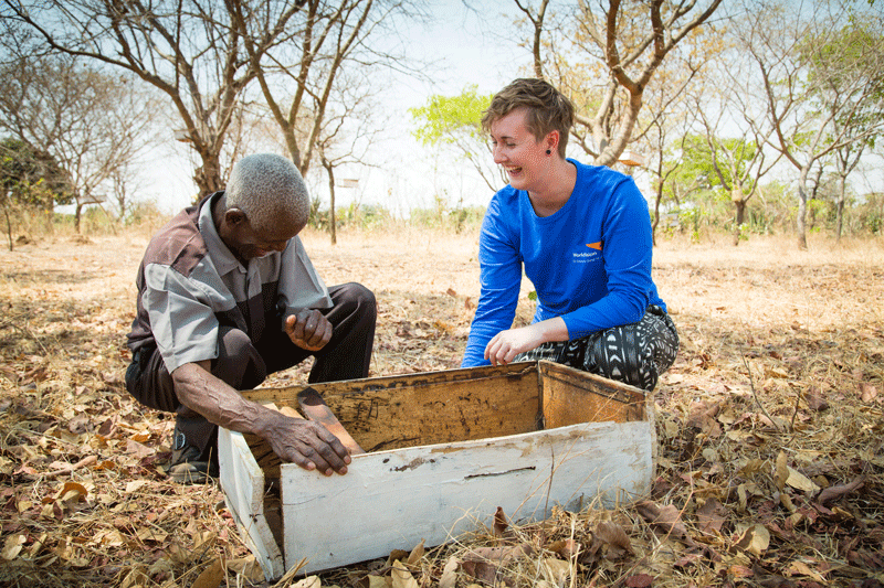 Bee farmer Ernest, from Tanzania, shares a laugh with World Vision Child Ambassador Katana Bosetti.