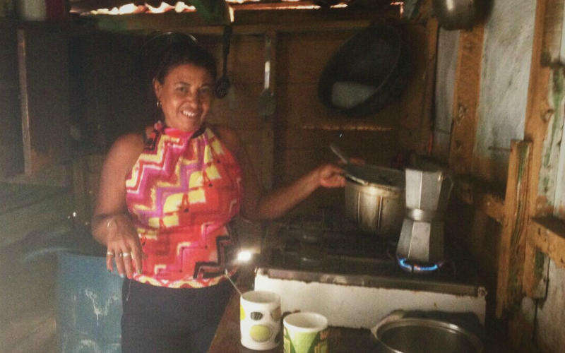 A woman makes coffee in a small kitchen