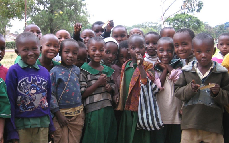 A group of children in Tanzania smile toward the camera.