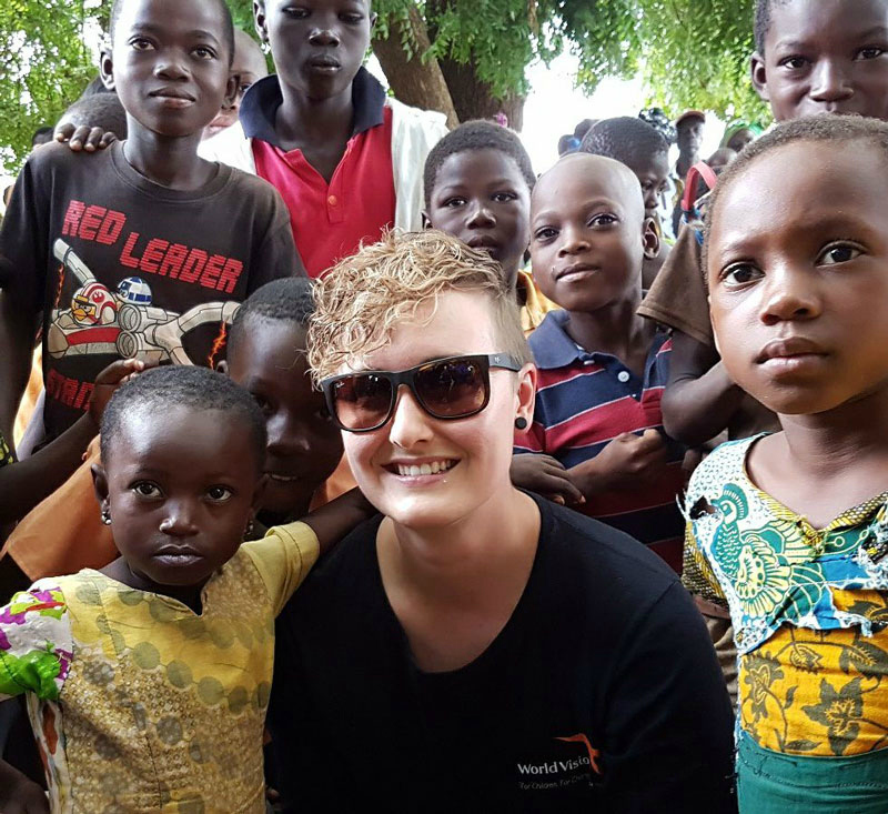 A Canadian child sponsorship ambassador is surrounded by children in Ghana