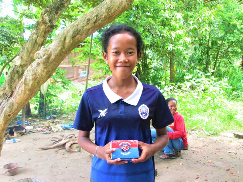 A girl from Cambodia holds a small box with the Lucky Iron Fish.