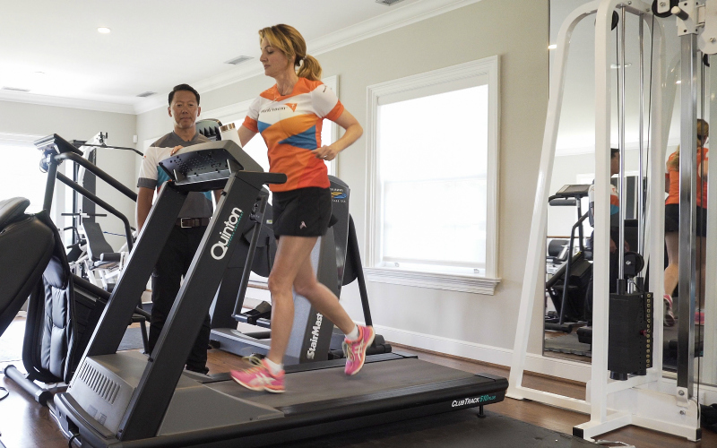 A man trains a woman on a treadmill.