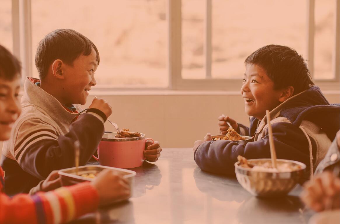 Children at a table enjoying a meal.