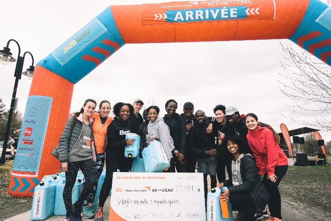 A team poses with a presentation cheque for $25,000 at the finish line for World Vision Canada’s Global 6k marathon.
