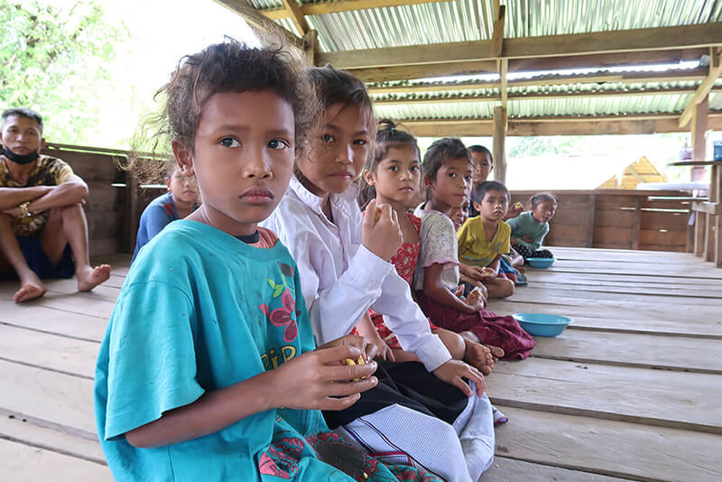 A group of children are seated as they participate in a community activity.