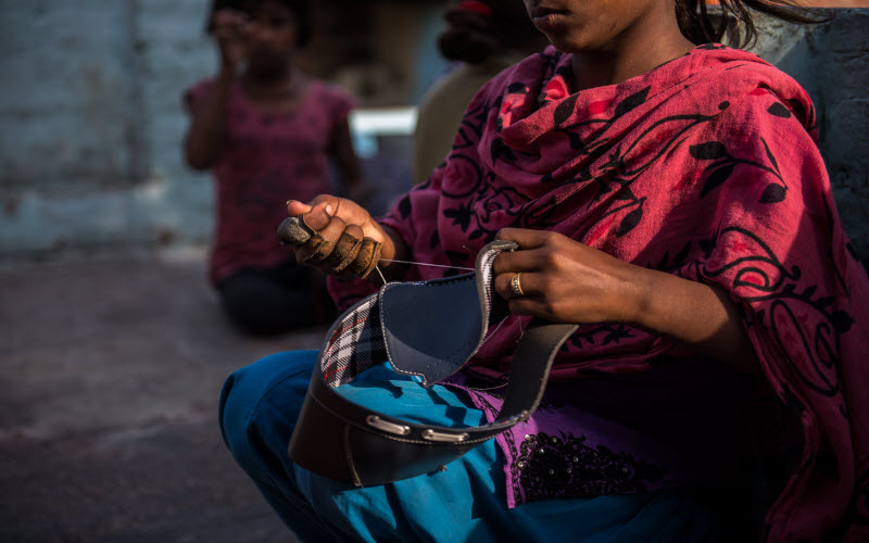 Twelve-year-old child labour Kanya from India is stitching leather shoes.
