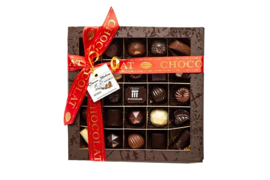 A box of assorted chocolate pralines with a red ribbon on top.