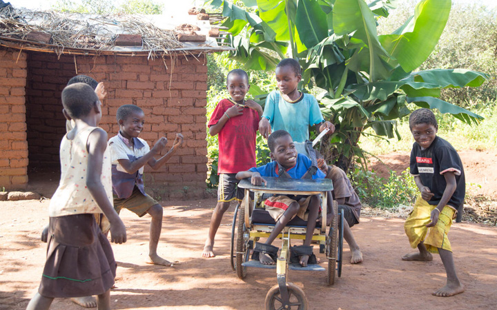 In Malawi, a boy who is using a wheelchair joins a game with other children.