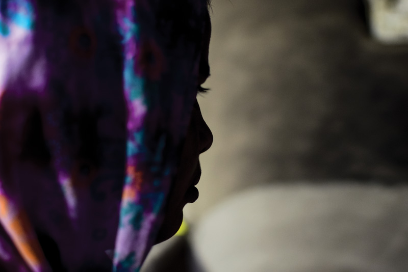 A profile of a young woman wearing a head scarf.
