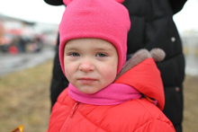 child in colorful winter clothes stare at the camera.