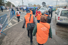 People wearing orange World Vision vests walk along the Romanian border.