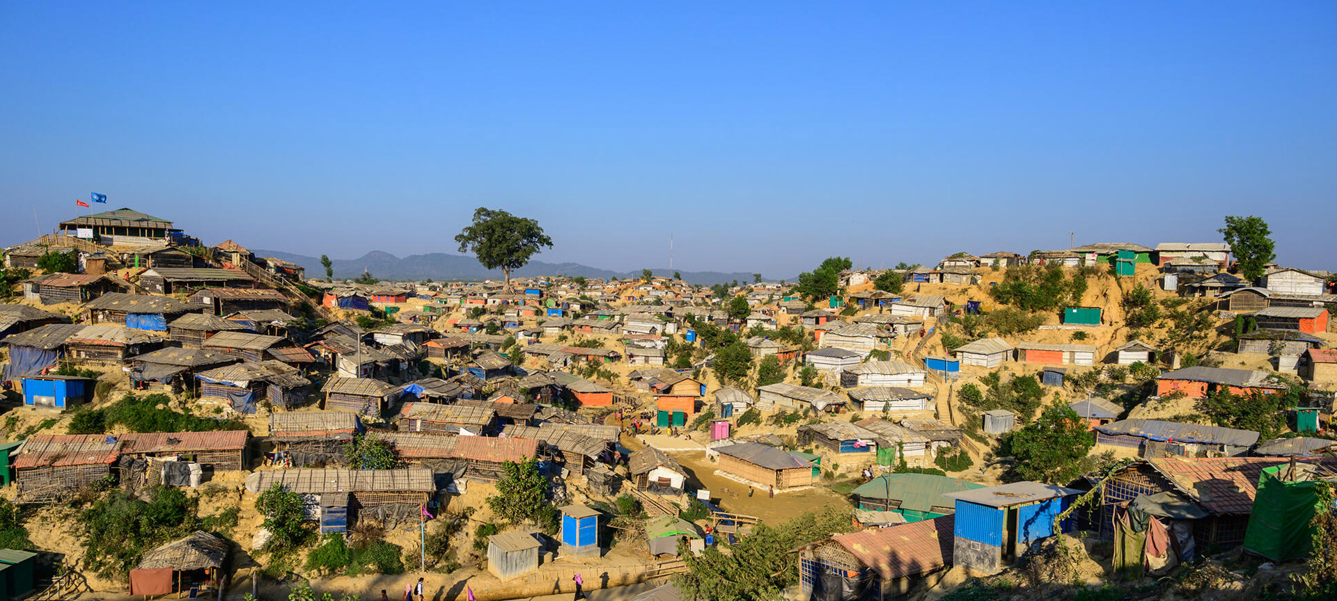 A birds-eye view of a hilltop village filled with small homes. 