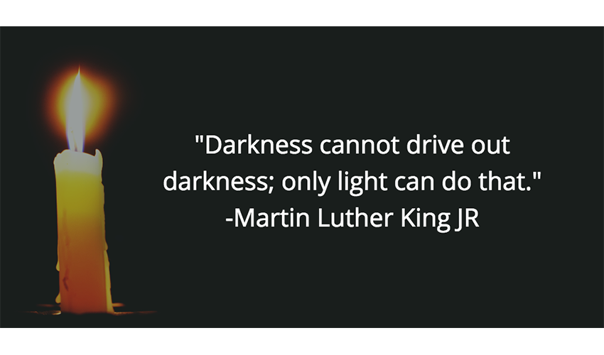 Lit candle with the words "Darkness cannot drive out darkness; only light can do that." Martin Luther King JR
