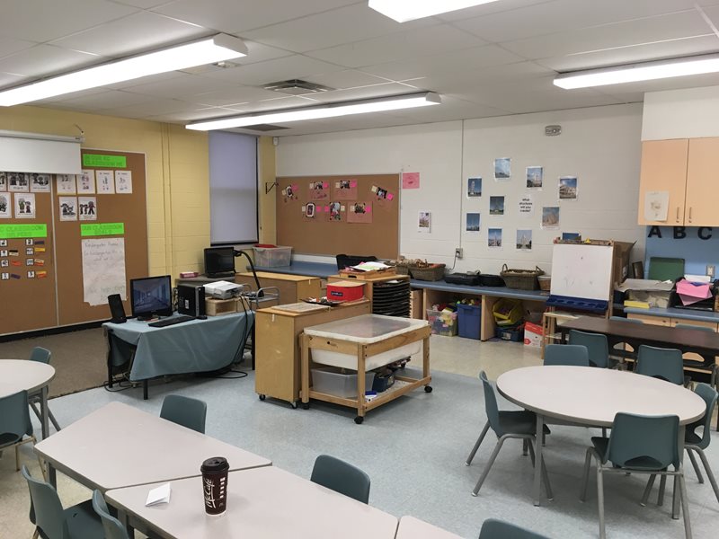 A classroom fully equipped with group tables, computer, materials and school supplies.