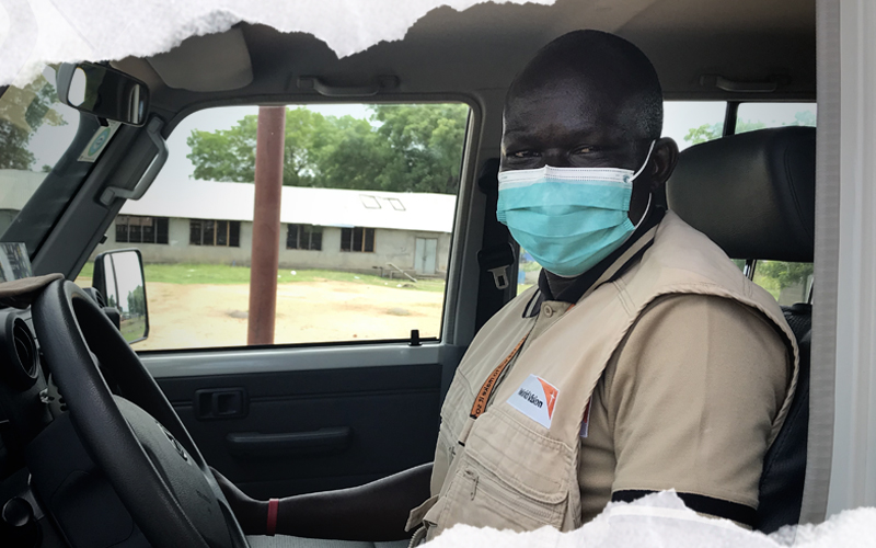 John Peter Lomoro, membre du personnel de Vision Mondiale au Soudan du Sud, est assis dans la fourgonnette qu’il conduit pour transporter les biens essentiels.