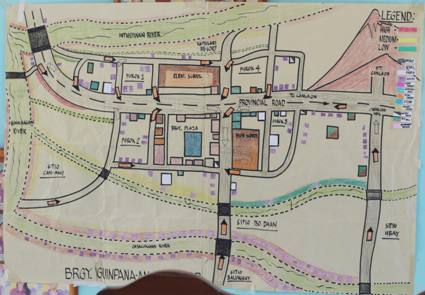 A colourful, hand-drawn map shows a small community in the Philippines with a volcano at the top right. 