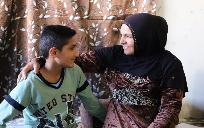 A boy and his mother look at each other lovingly as they sit at their home in Lebanon.