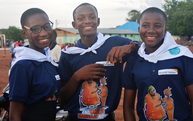 Three students pose together wearing, ‘End Child Marriage Now’ t-shirts.