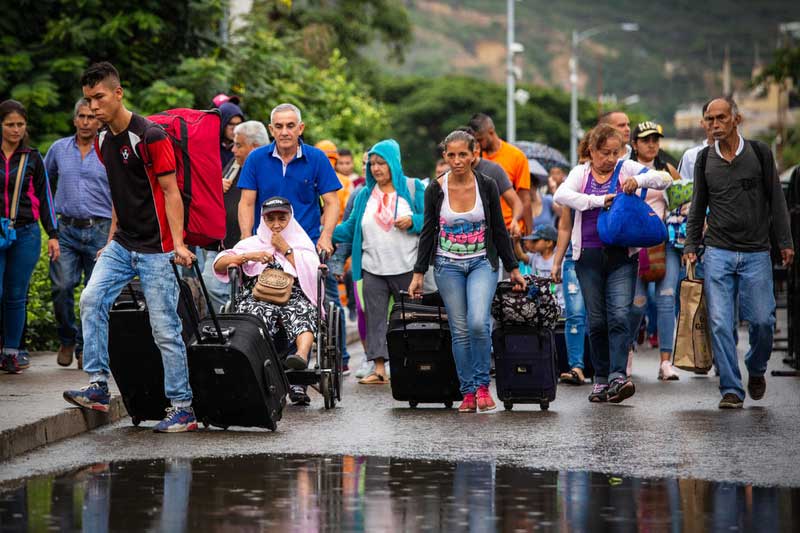 A crowd of Venezuela carrying their personal belongings cross the border with Colombia by foot.