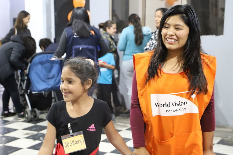 A World Vision staff plays with a Venezuelan girl at a child friendly space.