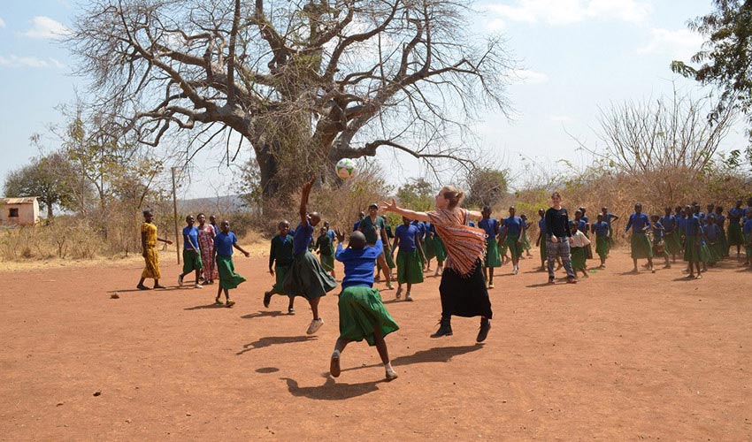 A group of Tanzanian school kids play a game of hand-ball with Canadians visiting their village.