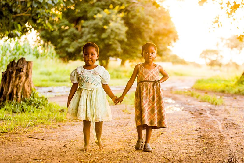 Barbara and Lulu, both 4 years old, walk home together from school each day in Zambia.