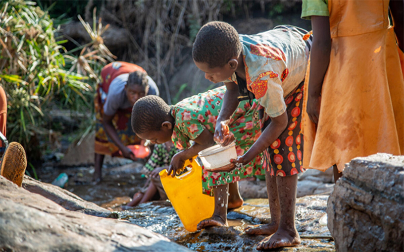 Ireen from Malawi gathers water from a stream.