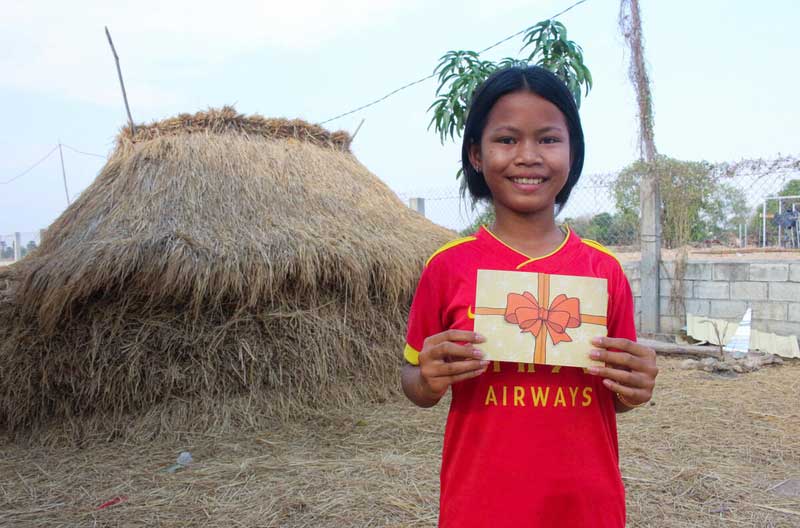 A Cambodian girl holding a Christmas card.