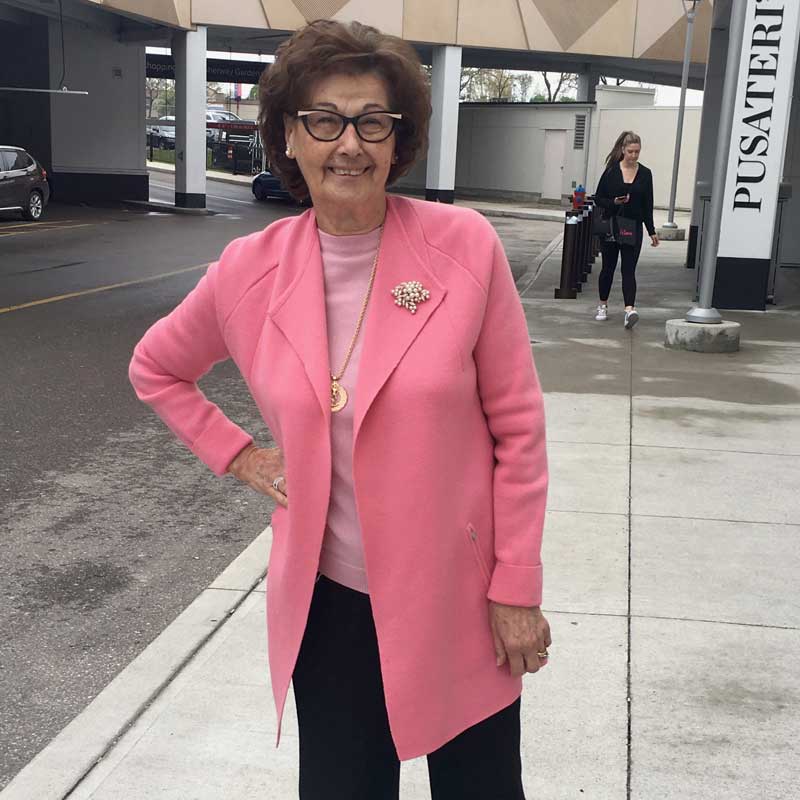 An older woman wearing a pink jacket.