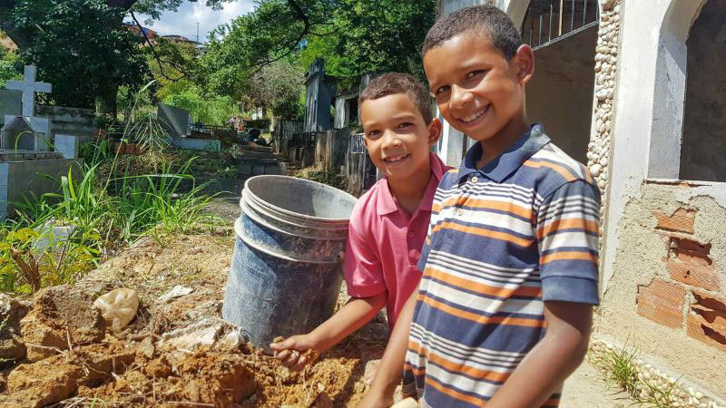 Two Venezuelan boys working at a cemetery.