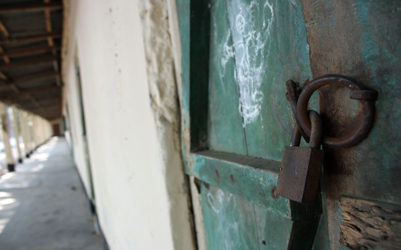 a rusty padlock on a wooden door painted green