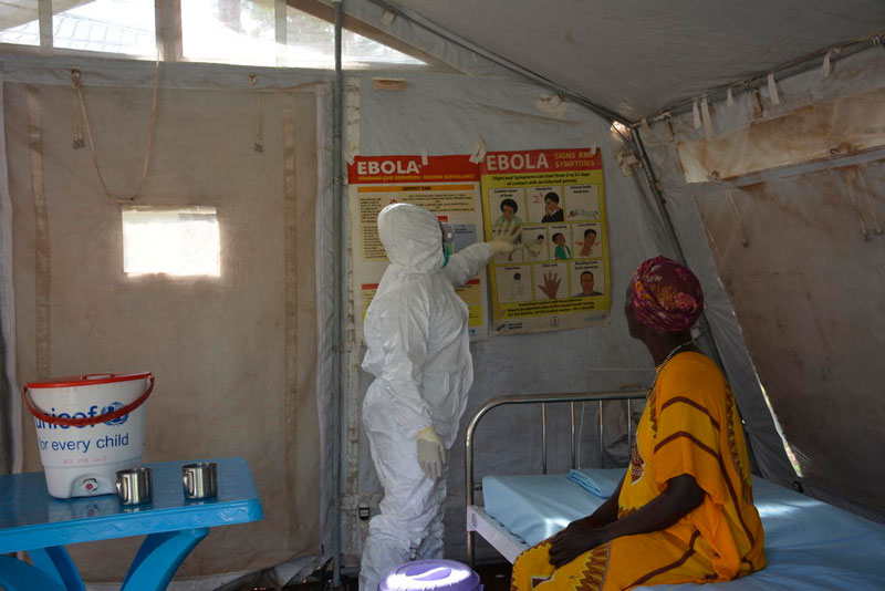 A healthcare worker shares information about Ebola prevention inside a medical tent.