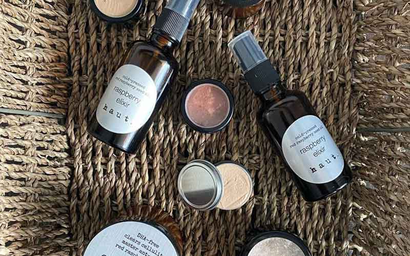 Makeup and skincare products from Haut Cosmetics laid out in a native basket.