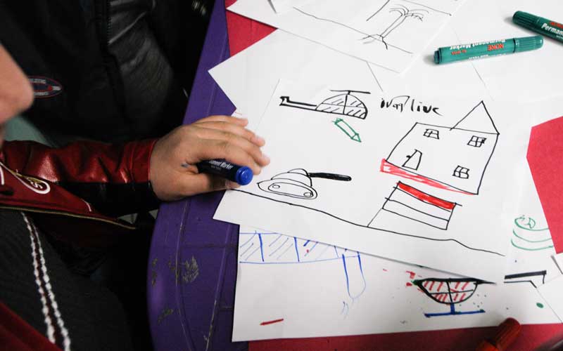 In Iraq, a child survivor draws a photo of what he experienced in his community.