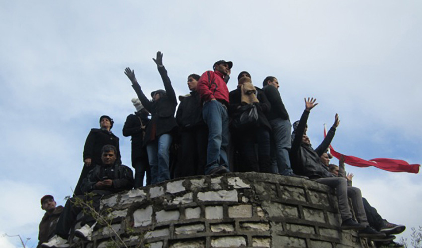 People protest atop a brick structure