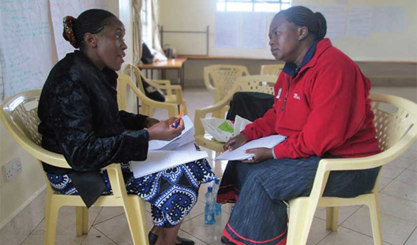 A health worker speaks to a fellow Kenyan woman