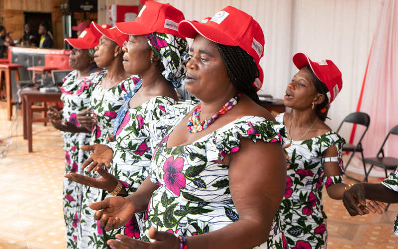 Women from DRC stand together and sing.