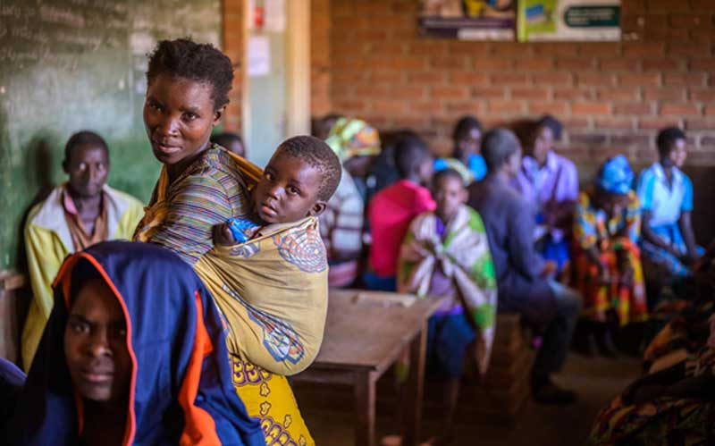 In Malawi, parents and children wait in the waiting room of health clinic.