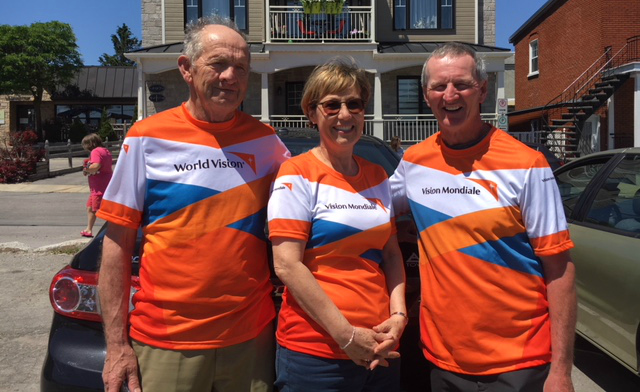 A group of three people in World Vision running shirts