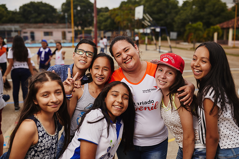 A World Vision staff smiles with a group of young women from Colombia.