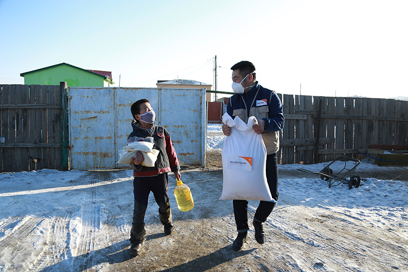 A World Vision staff walks beside a child from Mongolia.