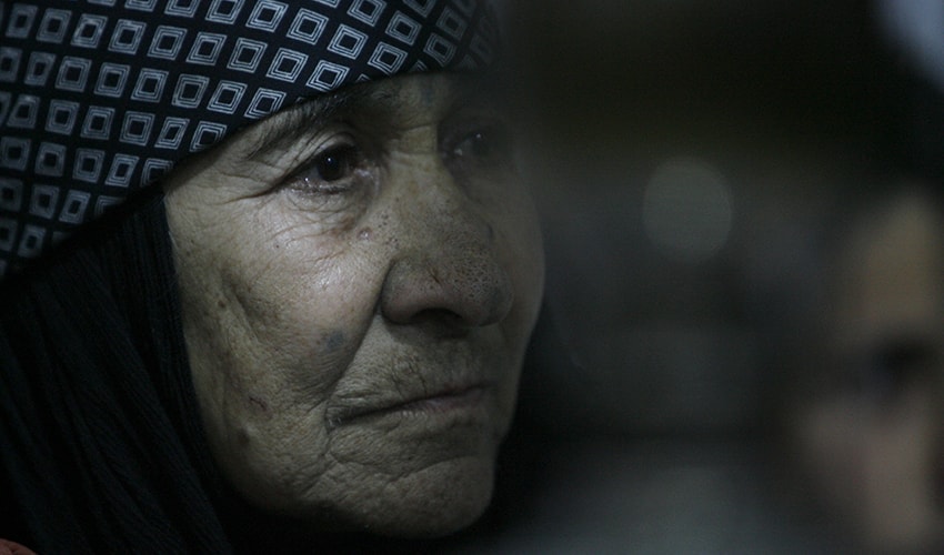 A close up of a Syrian woman whose face is marked with lines of age and wisdom.