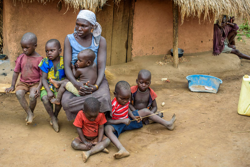 A mother with four of her small children sitting outside their home in a village in Uganda.