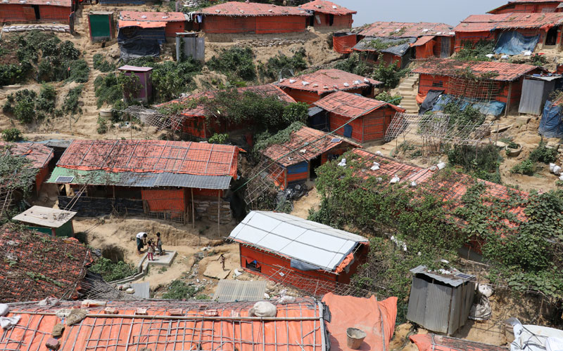a series of shanty homes built on hills with narrow dirt paths running between them
