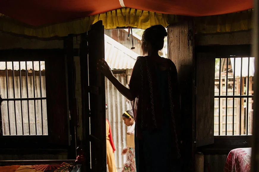 Farah, a child marriage survivor, is looking outside her home in Bangladesh.