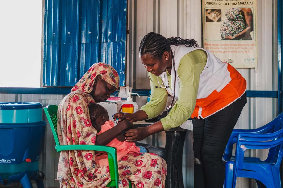 Heathcare worker helps mother treat baby in South Sudan