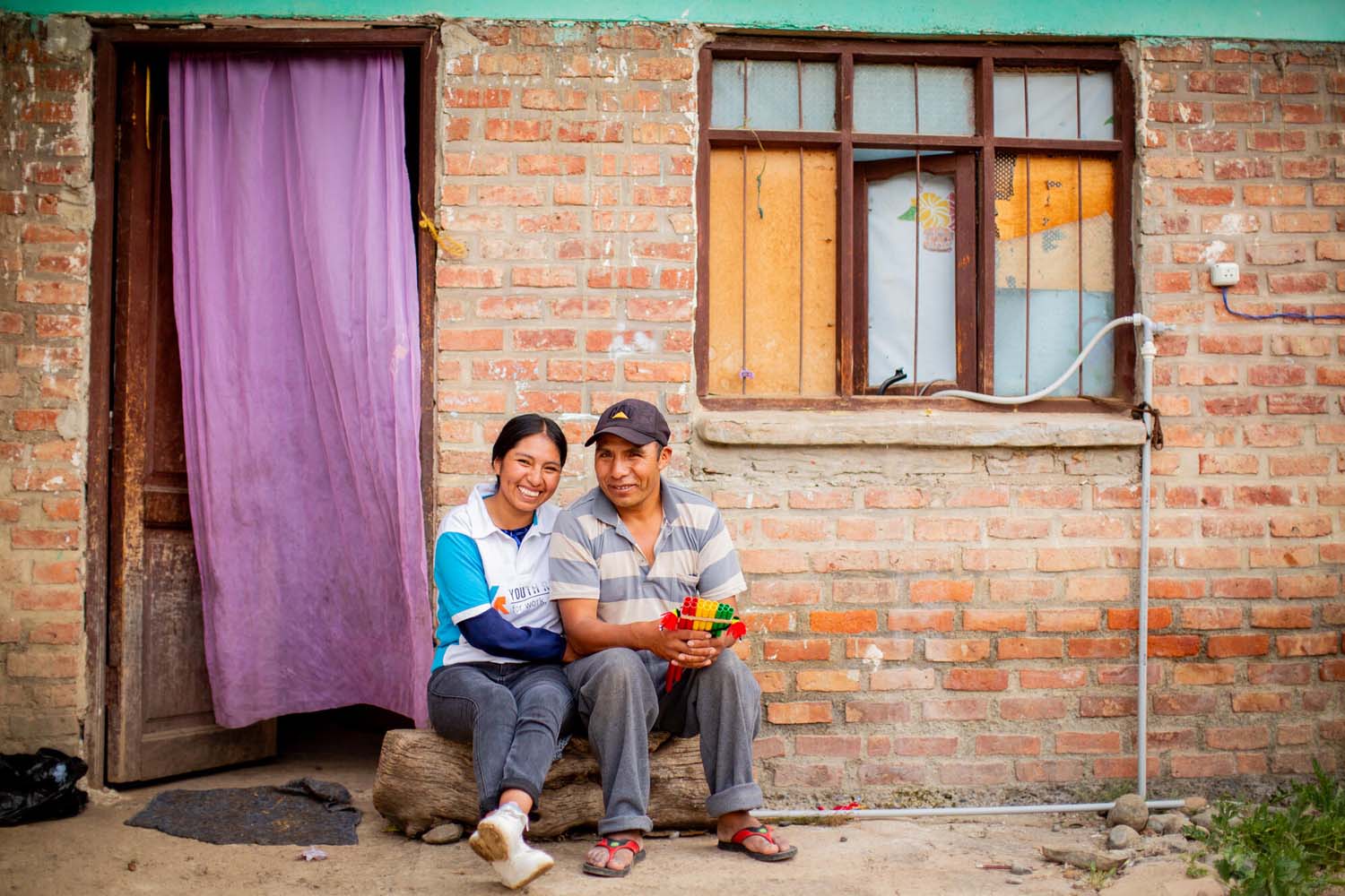 Youth Ready graduate Ana sits with her dad outside their home