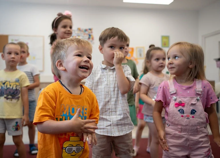 Children stand in an early childhood education classroom.